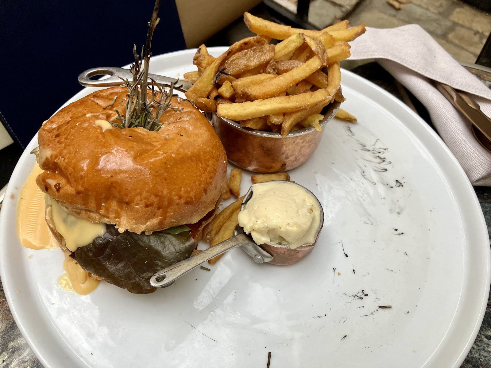 Burger brioche avec cheese, salade et frites maison servis dans un mini-chaudron
