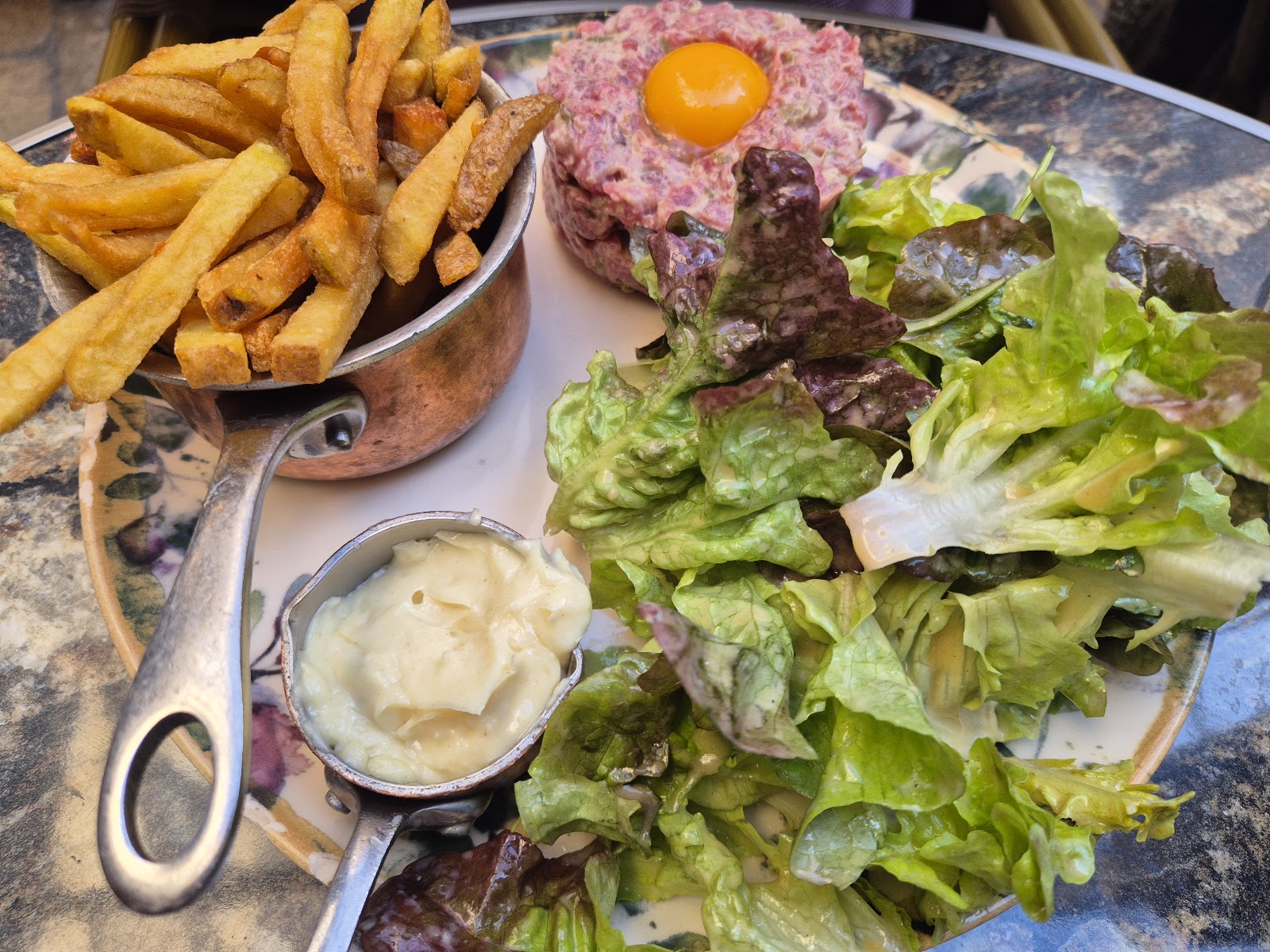 Steak tartare avec jaune d'œuf cru, frites maison et salade verte